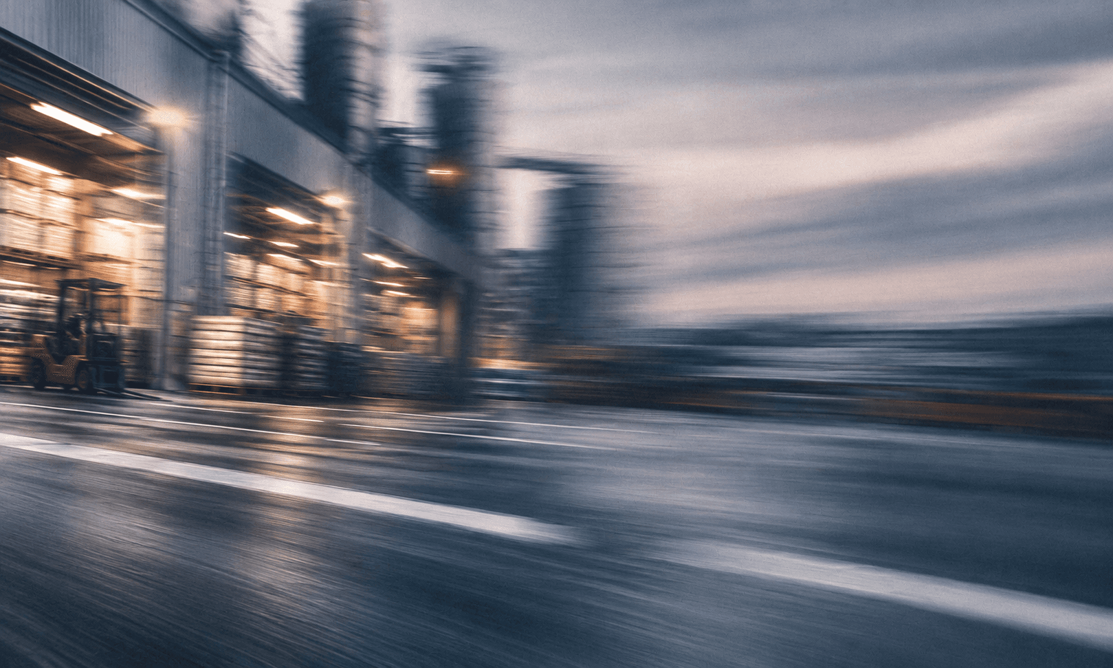 An active warehouse with a forklift and stocked industrial materials